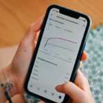 Person using smartphone to view social media analytics.