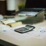 a calculator sitting on top of a table next to a laptop