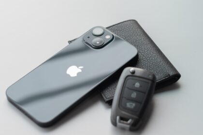 a cell phone sitting next to a car key