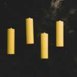 yellow pillar candles on black surface