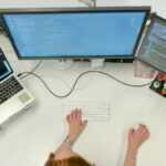 person using macbook pro on white table